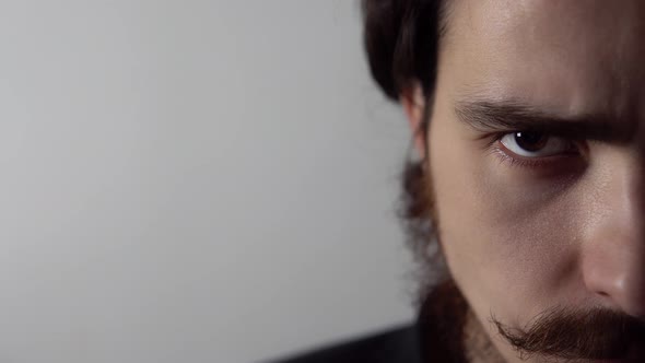 Portrait of Angry Young Bearded Man Frowning His Eyebrows Standing on White Background