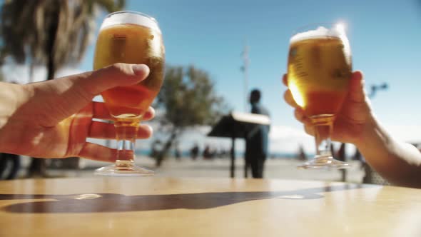 People Cheers Clinking Glasses of Beer on Beach Background