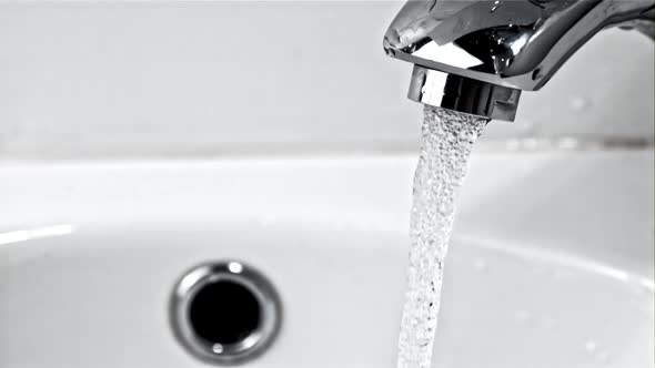 A Stream of Clean Water Pours From the Tap in the Bathroom