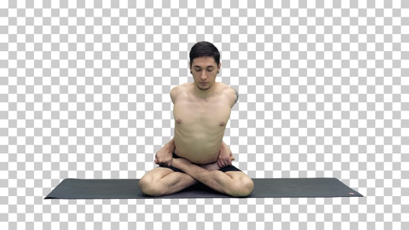 Sporty beautiful young man practicing yoga sitting cross-legged