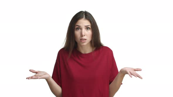 Video of Cute Brunette Woman in Red Tshirt Cant Understand Something Raising Hands Up and Looking