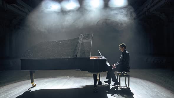 Pianist in Dark Suit Playing on a Grand Piano on Big Stage