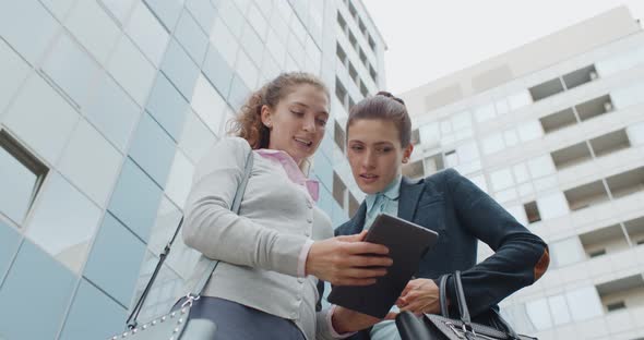 Low Angle View of Female Colleagues Using Digital Tablet Outdoors