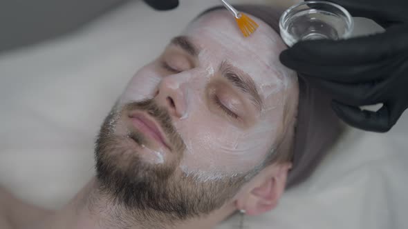 Closeup Male Hands in Gloves Applying SPF Masque on Moisturizing Face Cream for LED Light Therapy