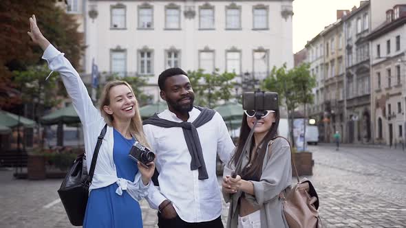 Satisfied Smiling Multiracial Friends Making Selfie in the Cente of City Street