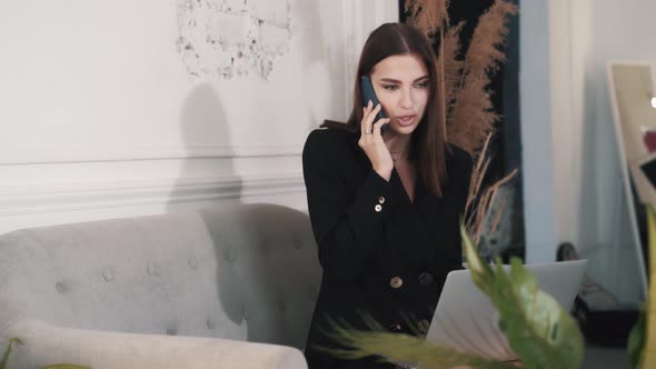 Pretty Young Business Woman Talking on Smartphone with Her Colleagues 