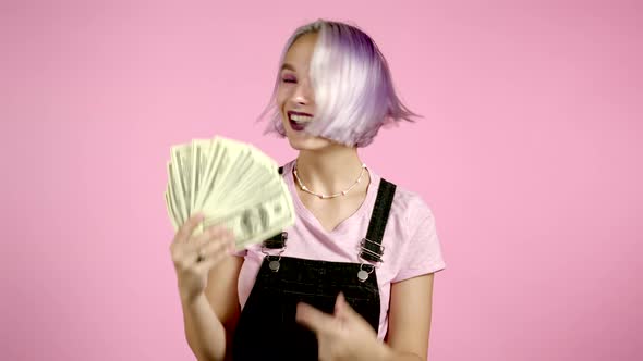 Amazed Excited Hipster Woman with Violet Dyed Hair Showing Money - U.S. Currency Dollars Banknotes