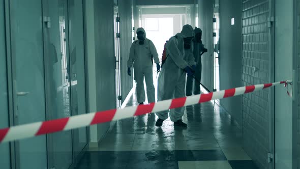 Sanitary Workers Are Cleaning a Hallway with Chemicals. Coronavirus, Covid-19 Concept.