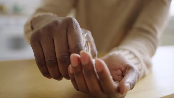Closeup of a Black Man's Hand Pouring Pills From a Jar Into His Hand