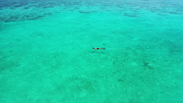 Two lovers suntan on paradise tourist beach lifestyle by blue green water with white sand background