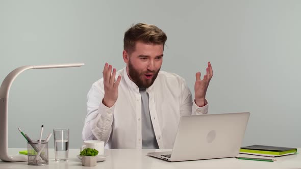 Young Man Typing on Computer Browsing Web Looking at Screen with Enthusiastic Wow Expression on His