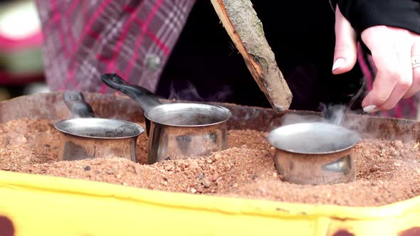 Preparation Of Turkish Coffee In The Turks On The Hot Sand On The Street