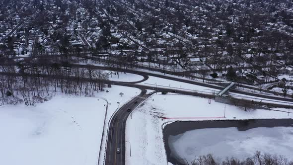 An aerial view from a drone, over a cleared road with a frozen lake on either side. It was during a