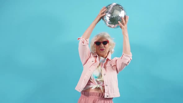 Funny Old Woman in Sunglasses Holding a Ball. Lifestyle, Woman Wants To Dance