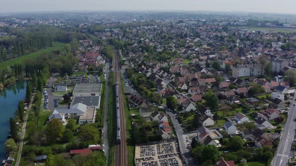 A train is riding across the residential district. 