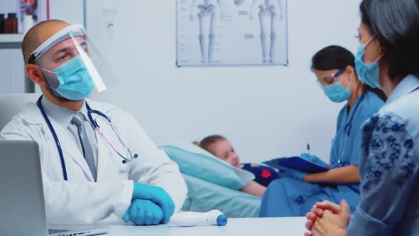 Nurse Consulting Child Laying in Bed