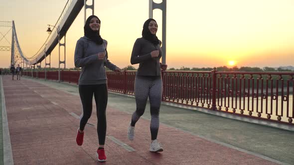 Healthy Muslim Females in Hijabs Running on Bridge