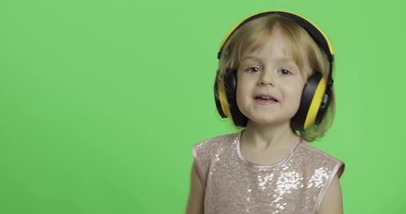 Girl in Glossy Dress and Headphone Listening To Music and Dancing. Chroma Key