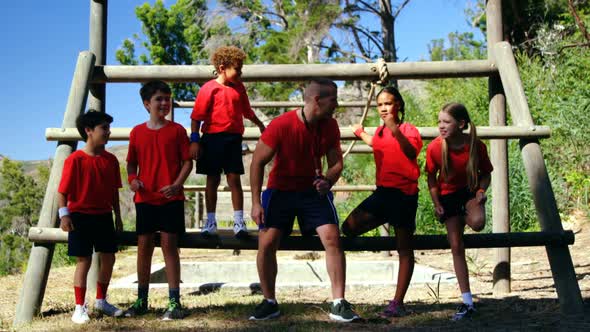 Trainer and kids relaxing in the boot camp