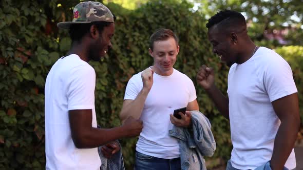 Three Multiracial Friends Play a Game and Laugh