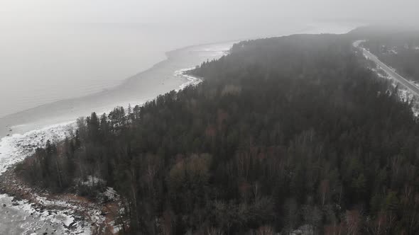 Snow Winter Shore Coast with Big Stones and Forest with Trees