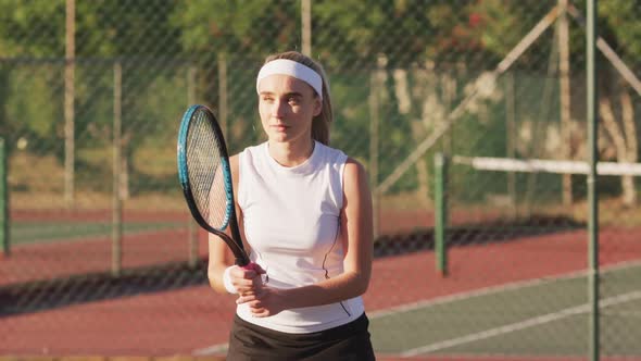 Video of focused caucasian female tennis player holding racket and hitting ball