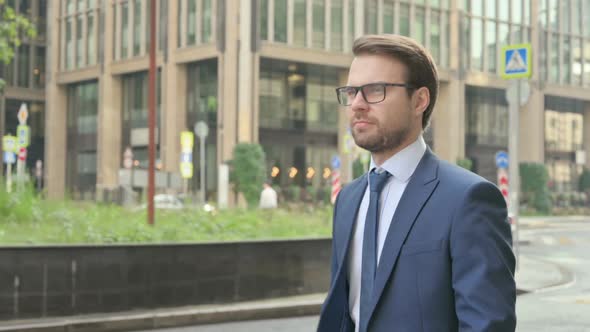 Attractive Businessman Walking in Street, Side Pose