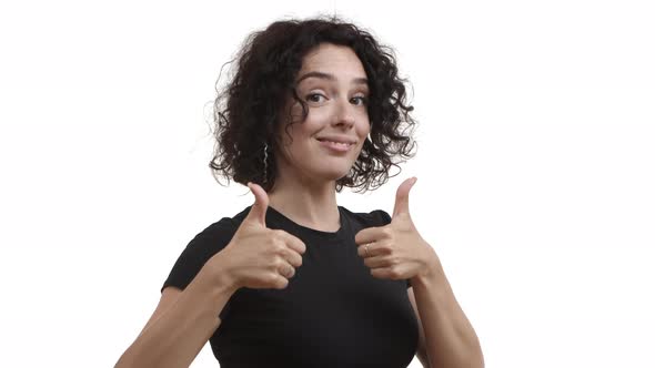 Young Attractive Female Model with Curly Short Hair Showing Thumbsup in Approval and Nodding