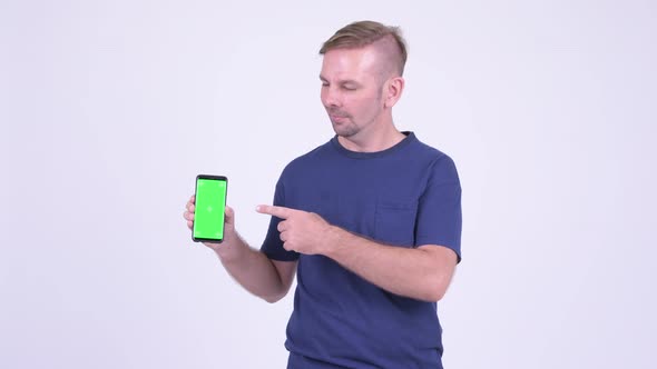 Portrait of Happy Blonde Man Showing Phone and Giving Thumbs Up