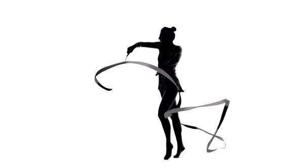 Girl Gymnast with Ribbon in Hand Revolve Around Him. Silhouette. White Background