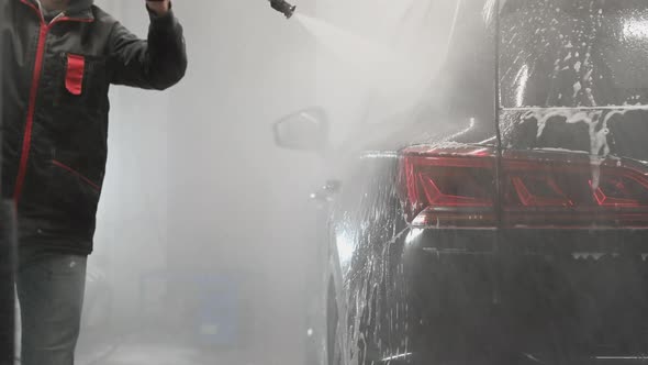 Worker at Car Wash Shop Using Pressure Washer on Car Man Washing Car with Compression Water