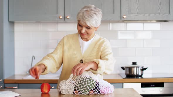 Woman with Vegetables in String Bag on Kitchen