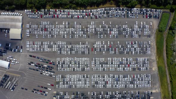 Aerial view of the parked new cars at the automotive plant. 