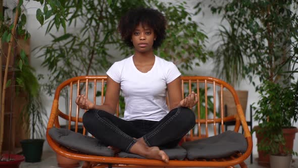 Front View of Mindful AfricanAmerican Young Woman Looking at Camera Closed Eyes Taking Deep Breath