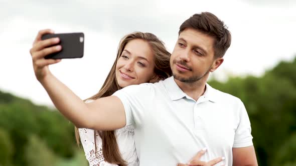 Romantic Happy Couple In Love Taking Photos On Phone In Nature.