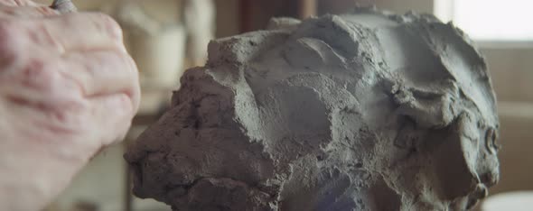 Hands of Senior Sculptor Shaping Head out of Clay