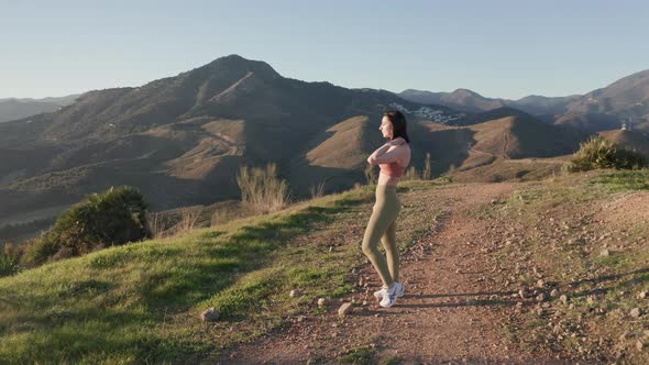 Woman Standing On Hill At Sunset