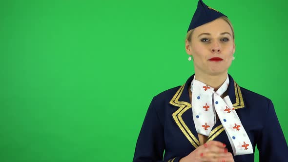 A Young Beautiful Stewardess Talks To the Camera with a Smile - Green Screen Studio