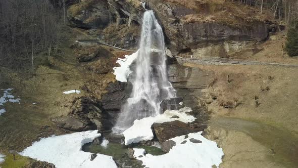 Aerial View Flying Over a Snowy Waterfall in Norway