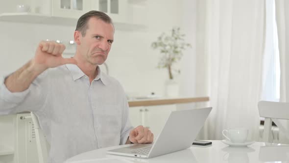Upset Middle Aged Man with Laptop Doing Thumbs Down