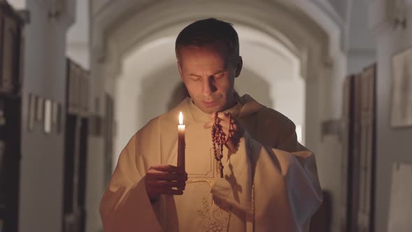 Priest Blowing Out Candle after Praying
