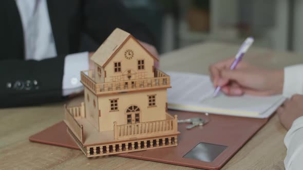 Close Up Of A House Model On The Table During The Signing Of House Purchase Contract