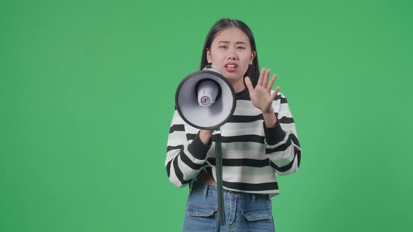 Asian Woman Speaking On Megaphone In The Green Screen Studio