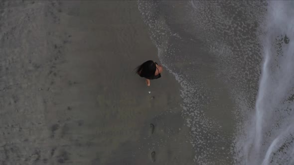 Top view of a woman walking on the beach