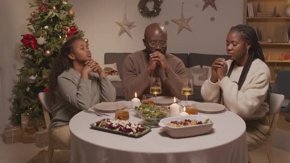 African-American Family Praying Before Christmas Dinner