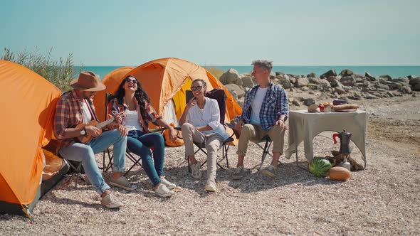 Picnic of Young Adult People and Ukulele on Beach with Tents