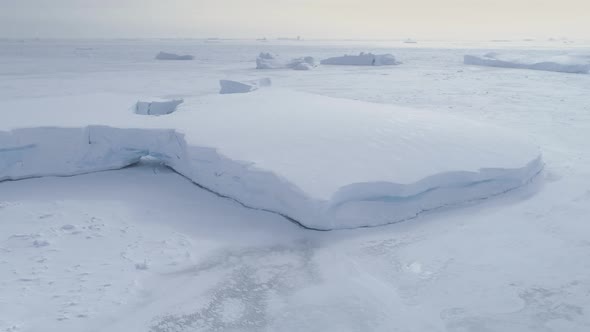 Tabular Iceberg Stuck in Frozen Ocean Aerial View