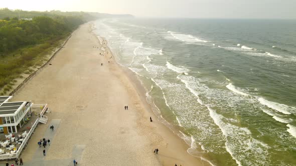 Beach Pullback Aerial Drone Over Cold Families Enjoying Gloomy Evening at Wladyslawowo Beach, Poland