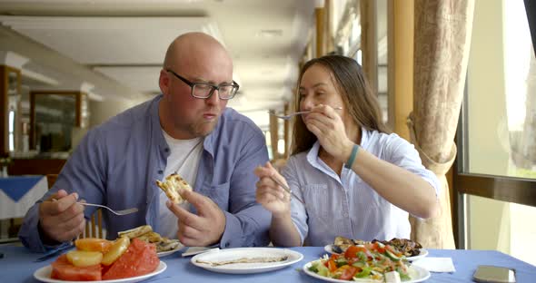 The Husband Bald and in Glasses and the Dark-haired Middle-aged Wife, Sit in Cafe, Eat, Treat Each