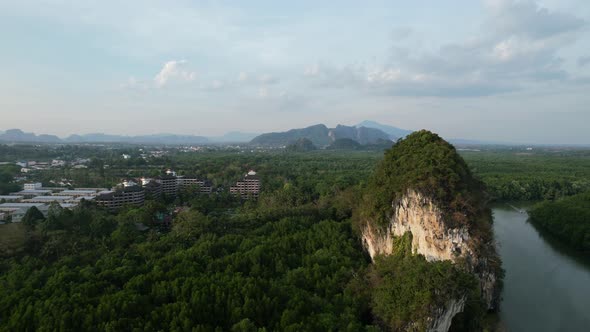 aerial drone panning right over a large limestone mountain rocks (Khao Khanap Nam) and resort in the